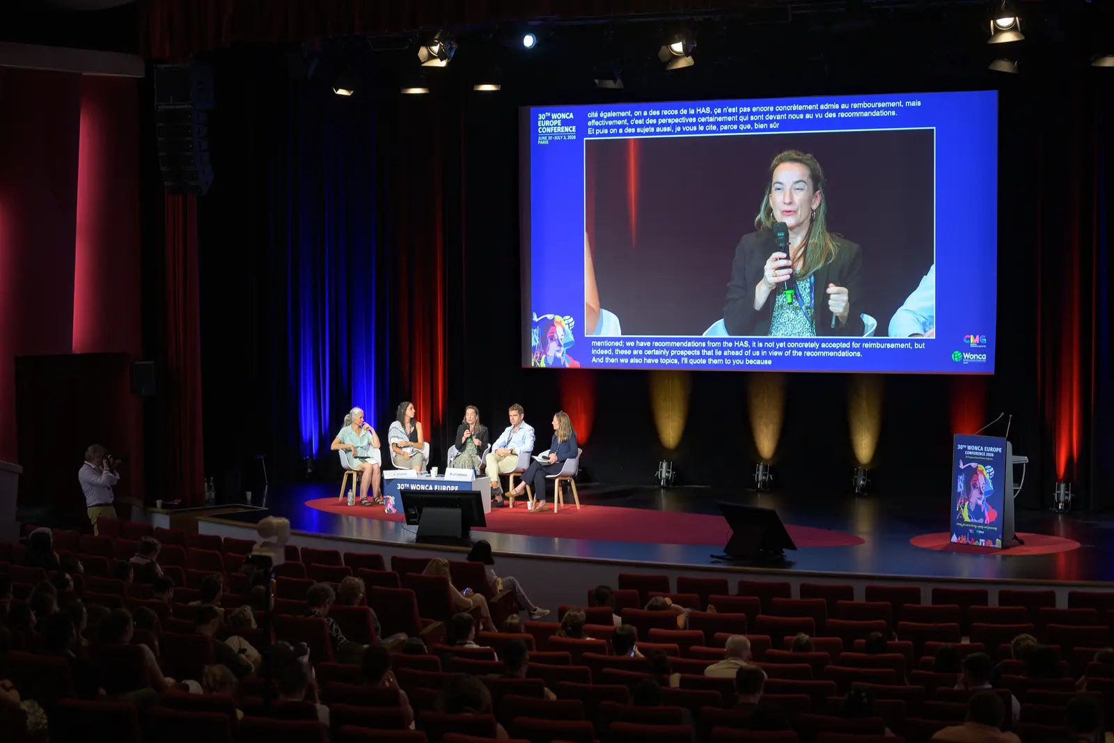 Vue de salle d'une plénière, intervenante à l'écran géant — BLH Photographie