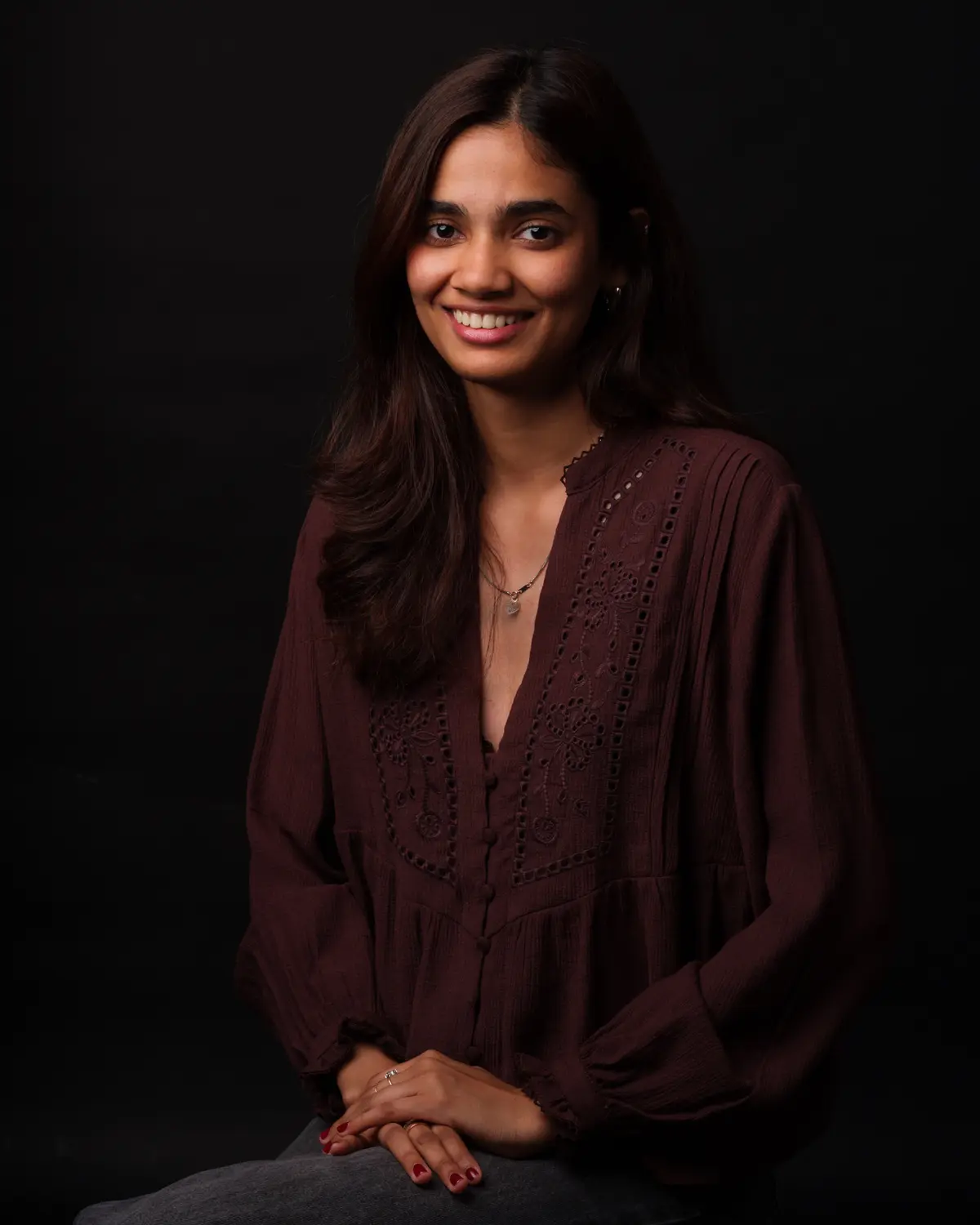 Portrait corporate d'une collaboratrice en blouse bordeaux — photographe d'entreprise à Paris