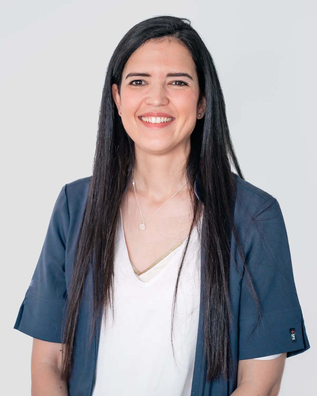 Portrait professionnel d'une collaboratrice souriante en veste bleue — BLH Photographie