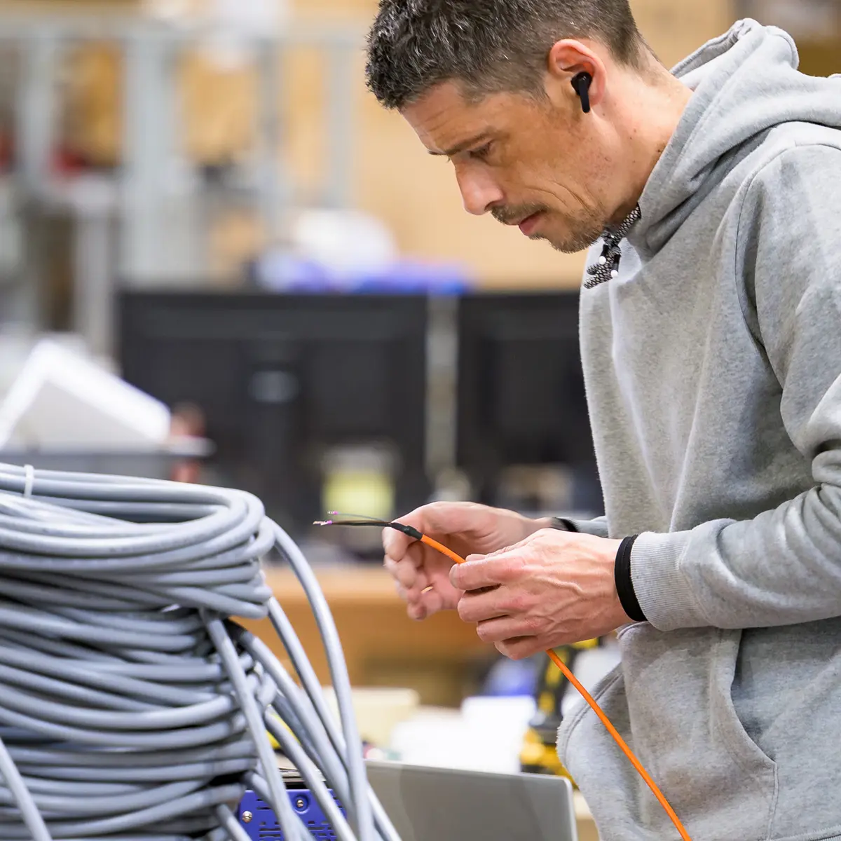 Technicien au travail dans un atelier de câblage — BLH Photographie